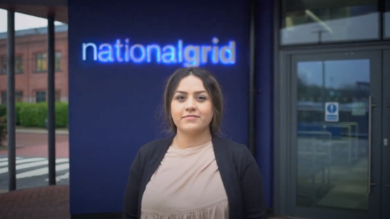 Maryam Eslami standing outside National Grid House below the company logo