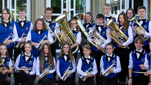 Youth brass band wearing uniform and holding their instruments