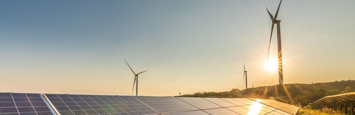 Solar panels and wind turbines at dusk