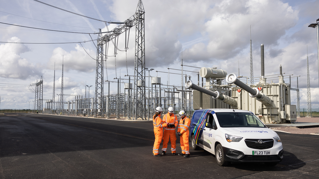 Three engineers wearing PPE standing next to National Grid branded van in front of a converter station