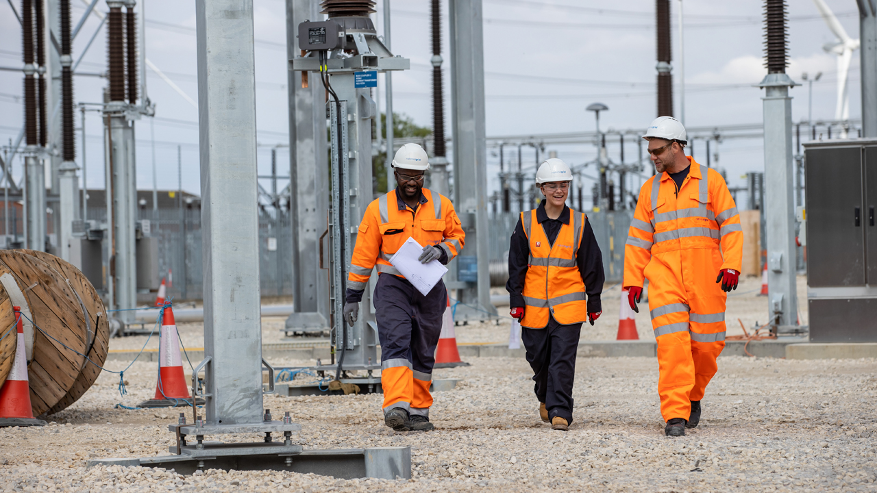 An apprentice and engineers wearing PPE at a substation construction project