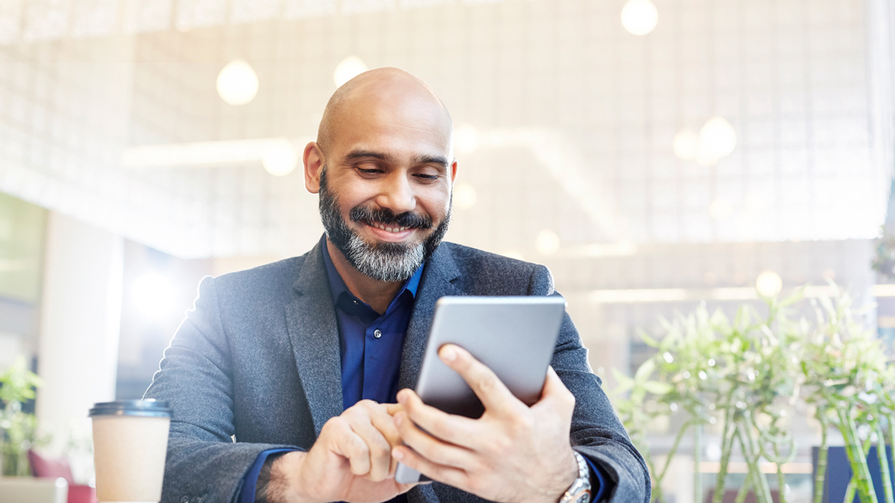 Man wearing a suit working on a tablet in an office