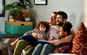 Cheerful family with young children on sofa