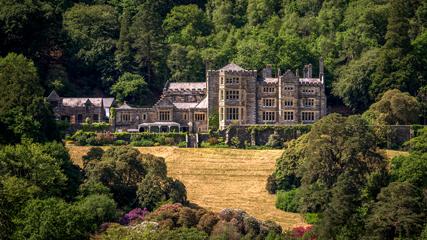 Cultural heritage building in Snowdonia AONB - 427x240 Beautiful old stone manor building in front of yellow field with woods behind