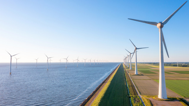 Wind turbines along a shoreline and offshore wind farm