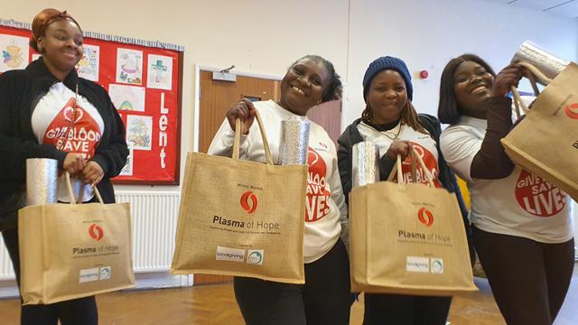 PlasmaOfHope_WestMidlands_640x360.jpg Four smiling women holding Plasma of Hope tote bags with winter warmth kits