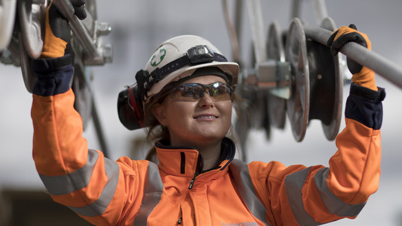 Female engineer wearing PPE holding National Grid high-voltage power cables