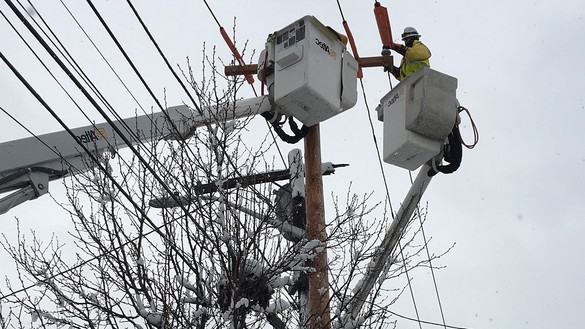 National Grid lineworker fixing a power line in the snow in the US
