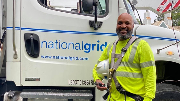 US Lineworker Donald Lopes in front of National Grid bucket truck