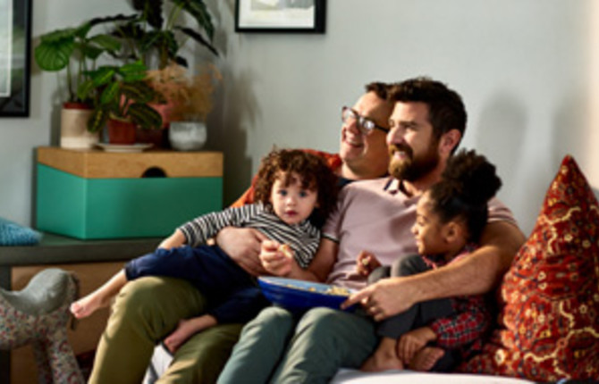 Cheerful family with young children on sofa