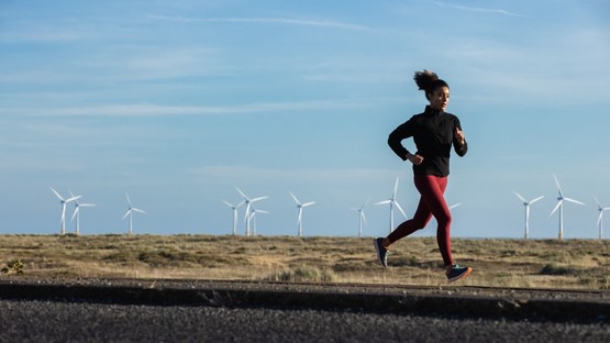 Woman running near windfarm